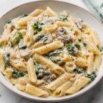 Bowl of creamy pasta without heavy cream topped with parmesan and cracked black pepper